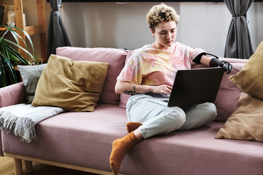 woman using laptop on sofa