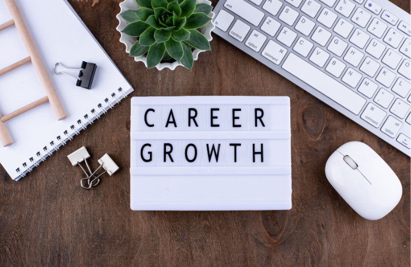 career growth sign on desk with keyboard mouse and plant