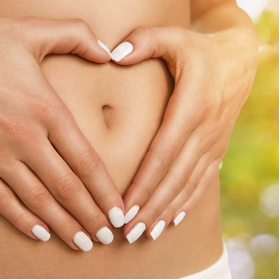 Hands making a heart shape on a stomach