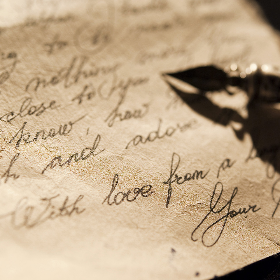 Letter and antique quill on a black background