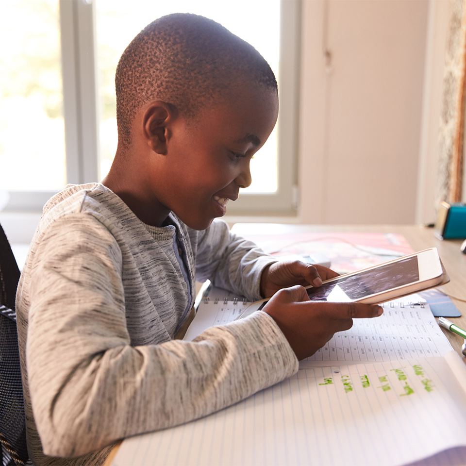 A boy in his bedroom learning year 5 maths on his tablet