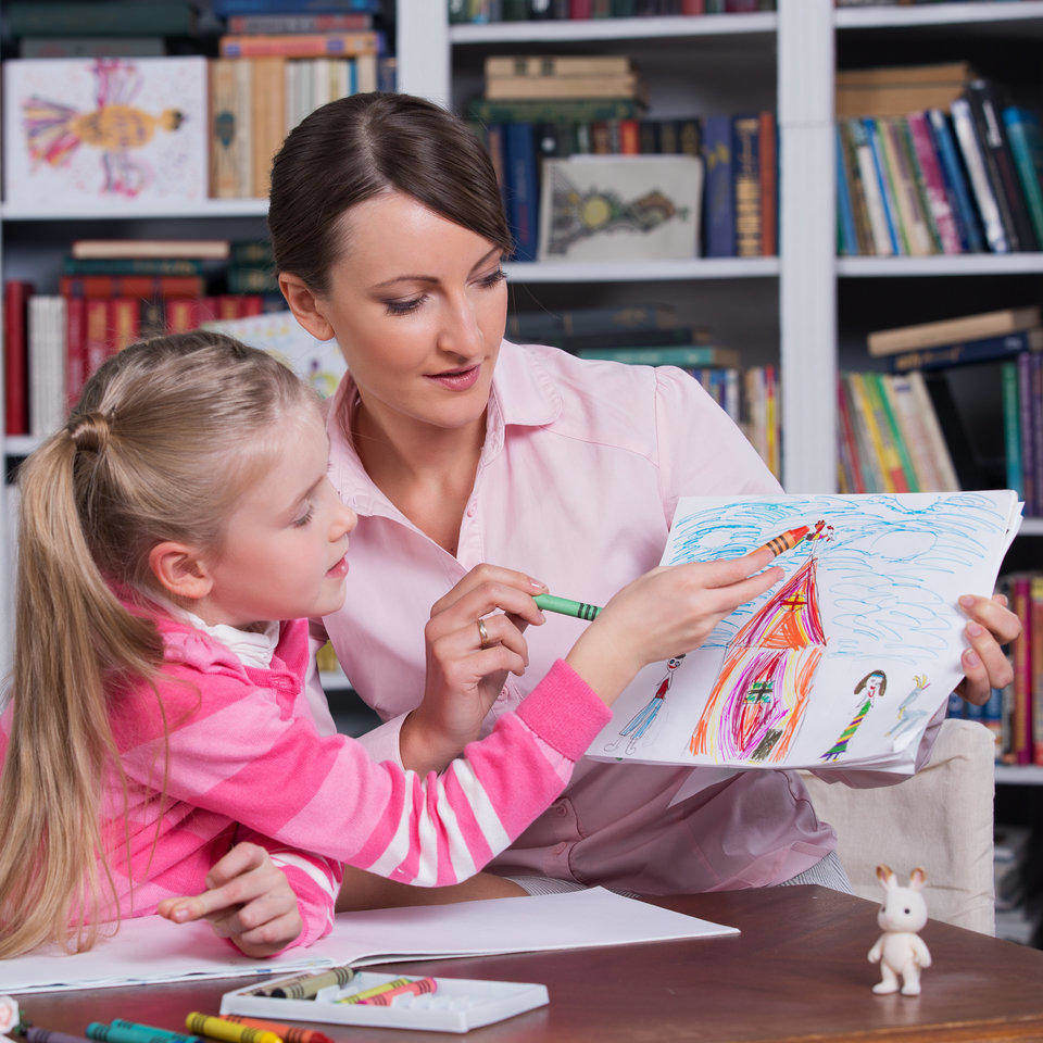 A child psychologist helping a little girl