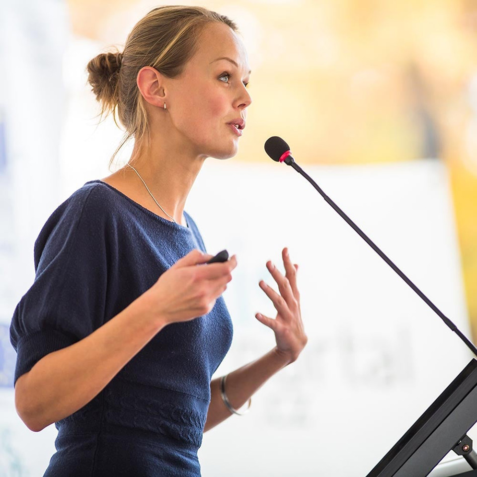 A motivational leader speaking at a microphone.