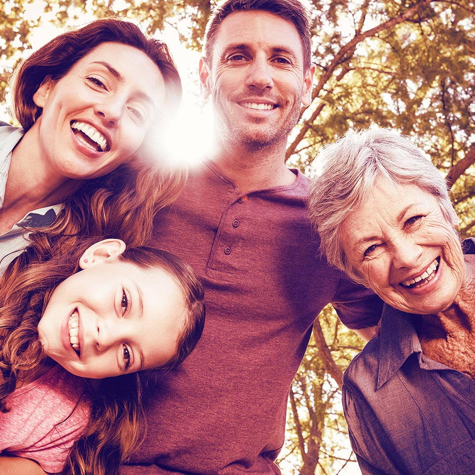 Portrait of happy family of three generations in a park.