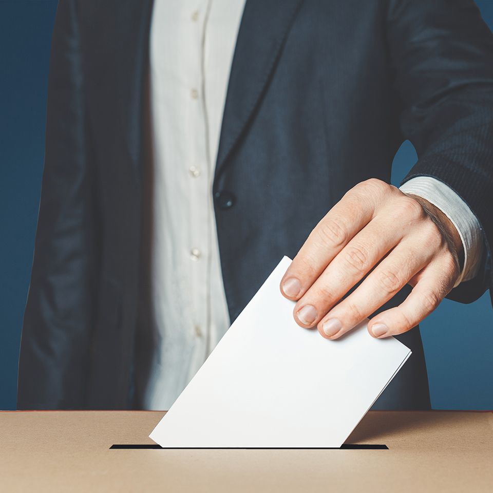 A voter placing their vote into a ballot box