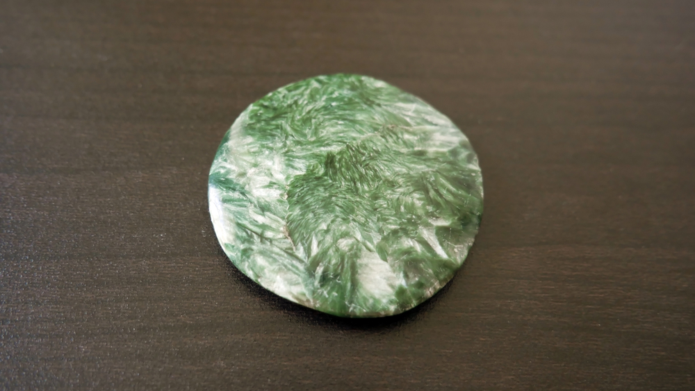 A piece of Seraphinite on a wooden background