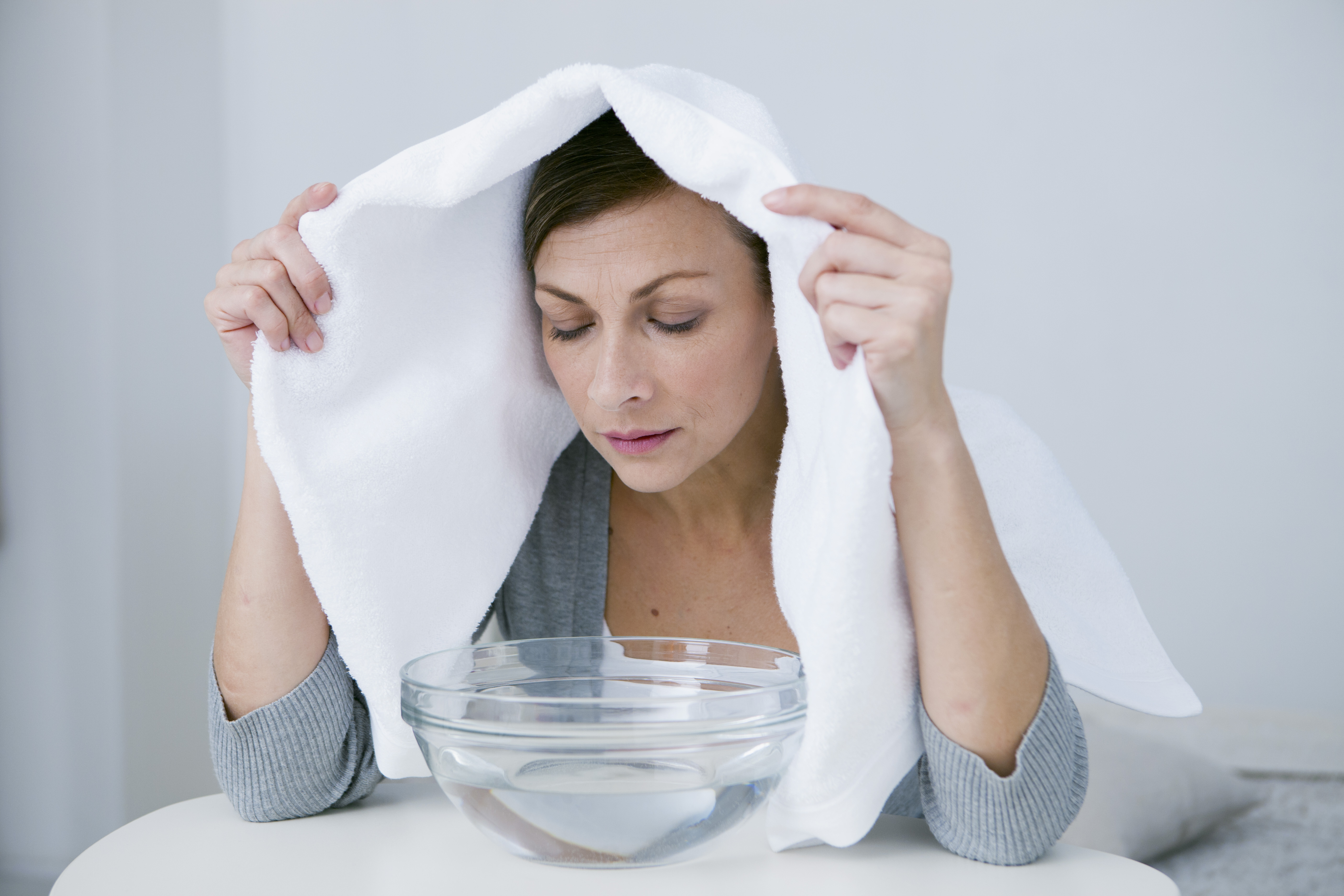Person inhaling essential oils in a bowl for congestion