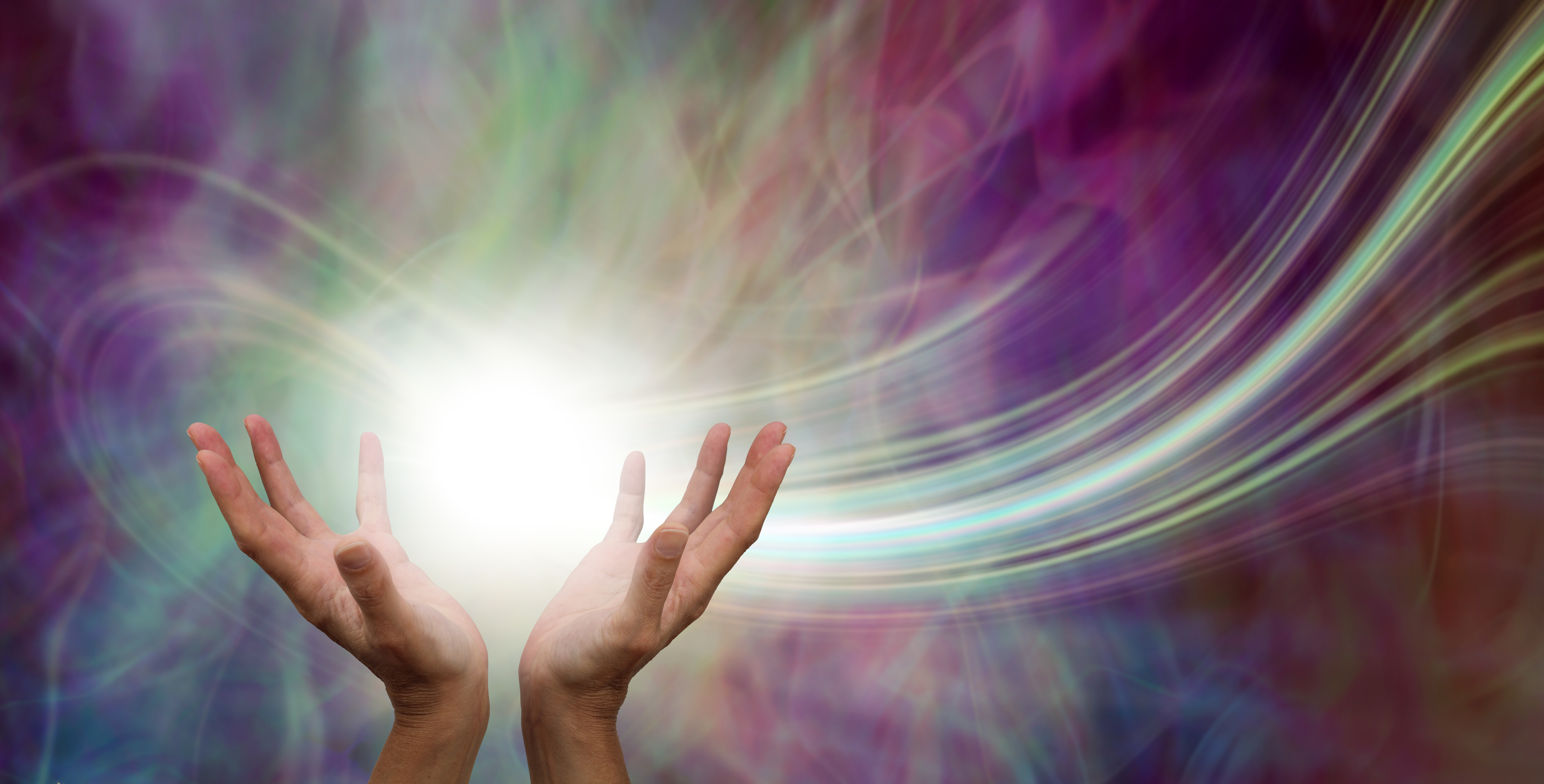 Hands reaching up into a ball of white energy with a laser trail and pink green ethereal energy field background