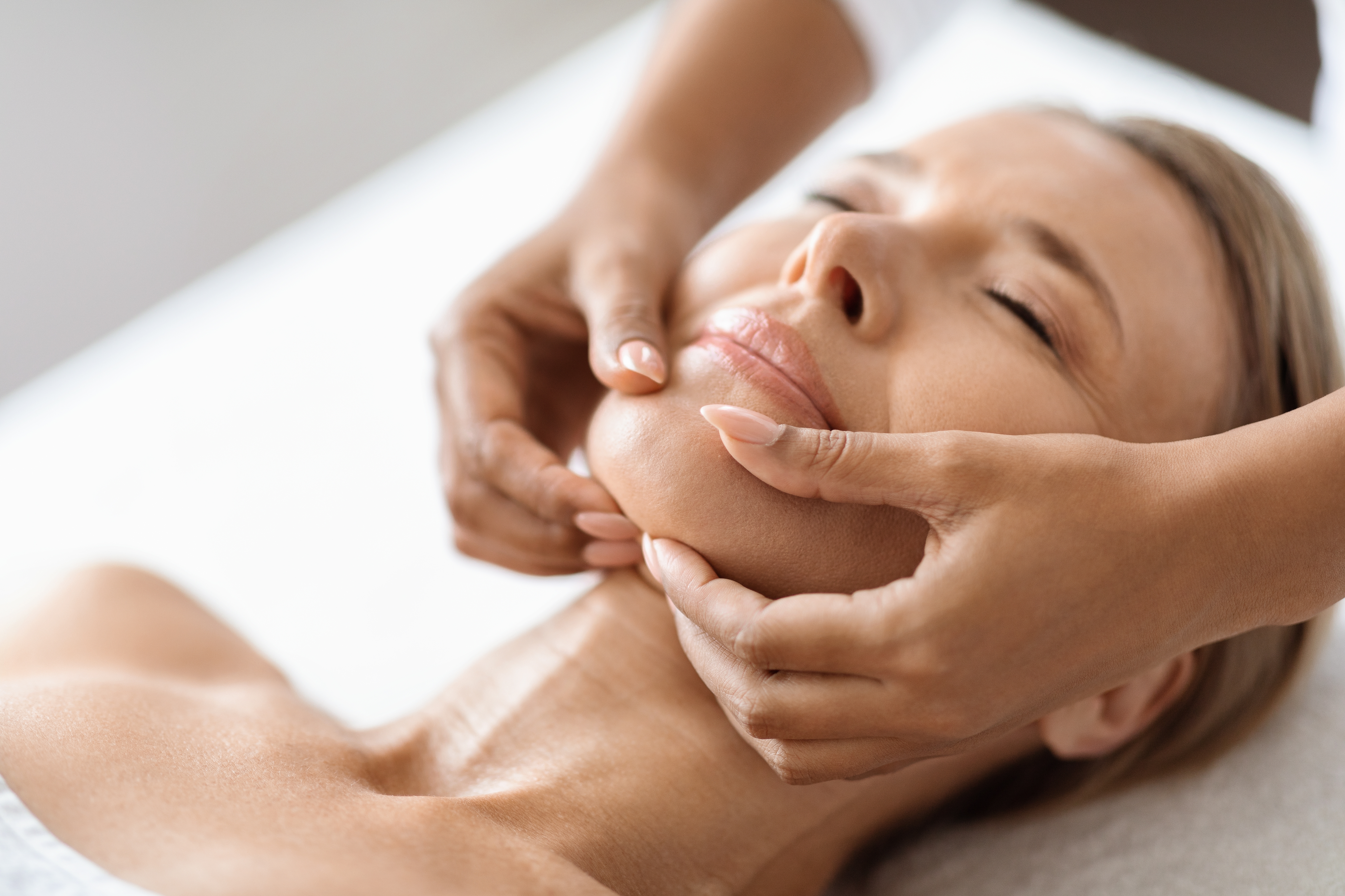 Face massage of chin on woman