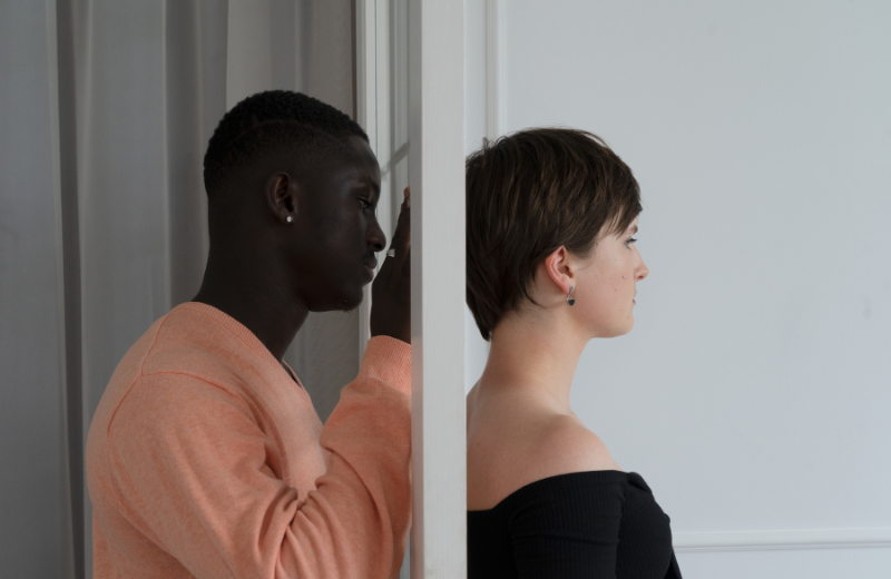 man staring at partner through door