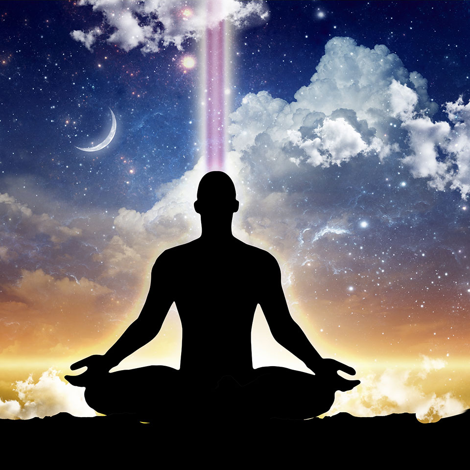 Silhouette of man meditating in front of a starry background