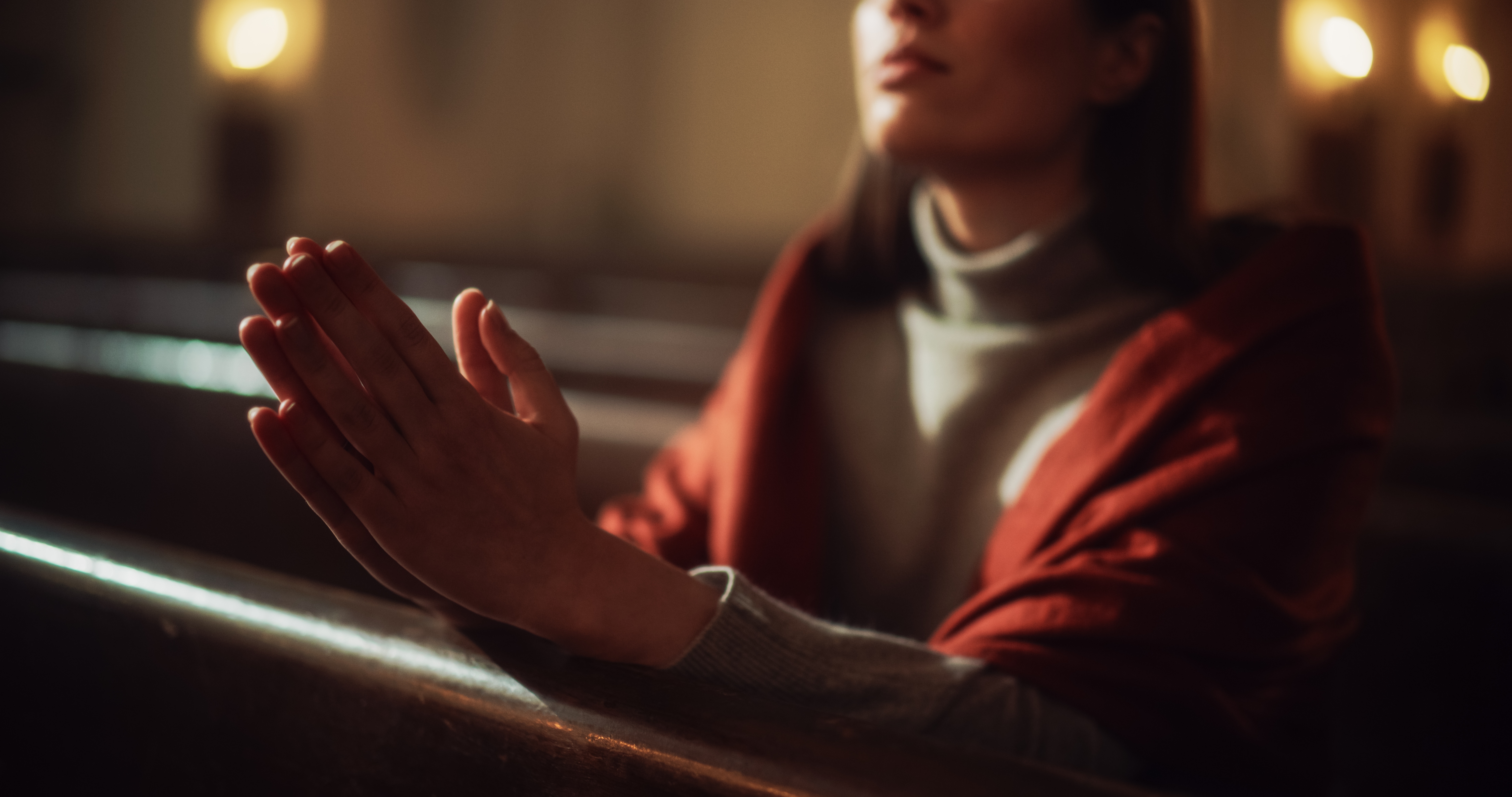 Woman praying in a dimly lit church