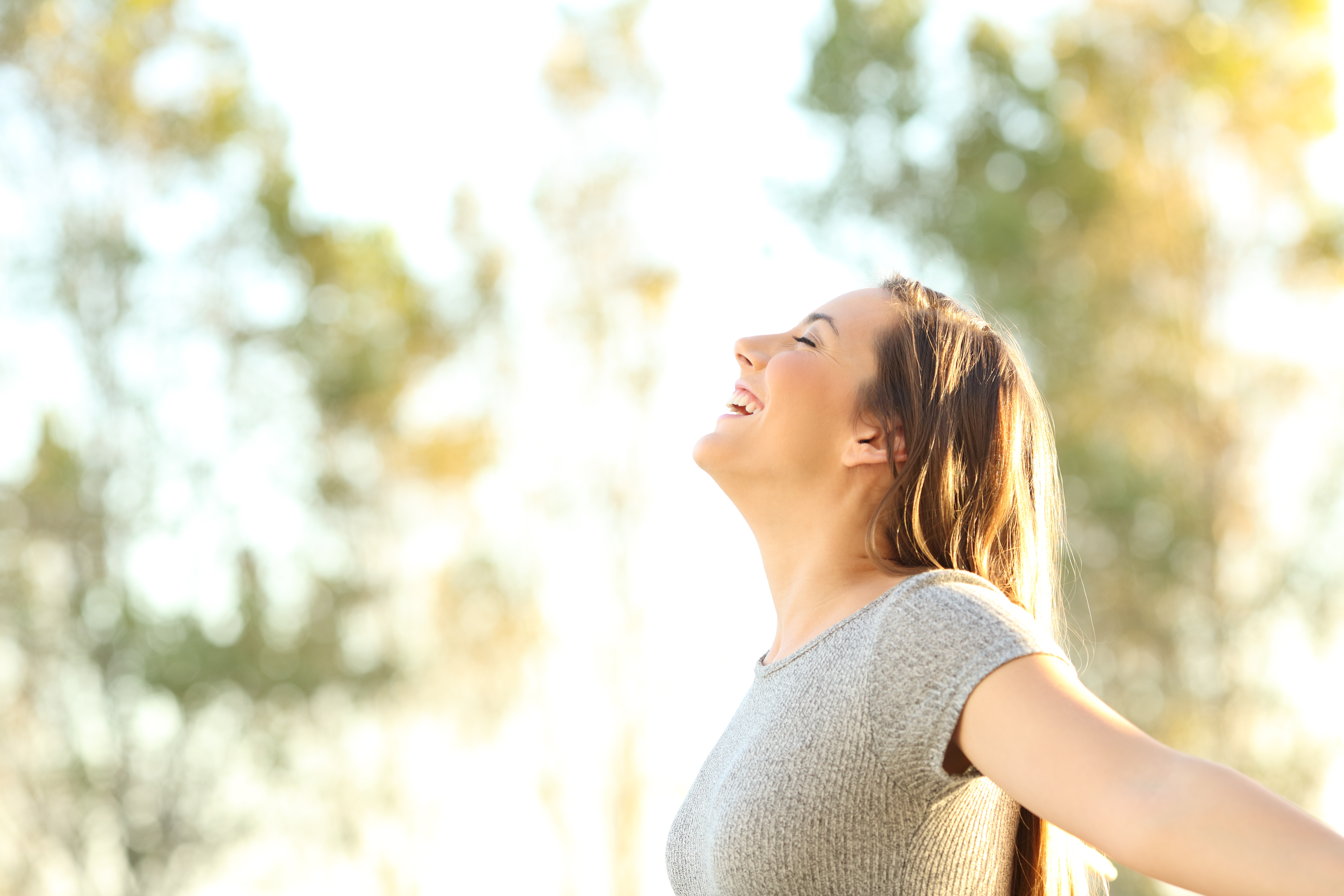 Side view portrait of a woman breathing fresh air outdoors in summer