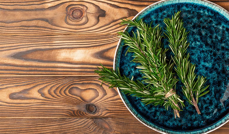 Fresh rosemary on a plate, ready for use in herbal recipes 