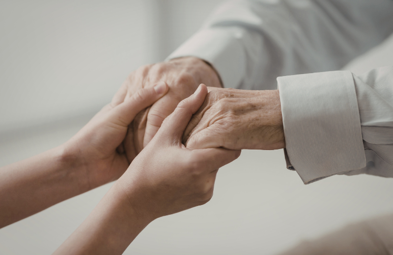 younger person holding older hands