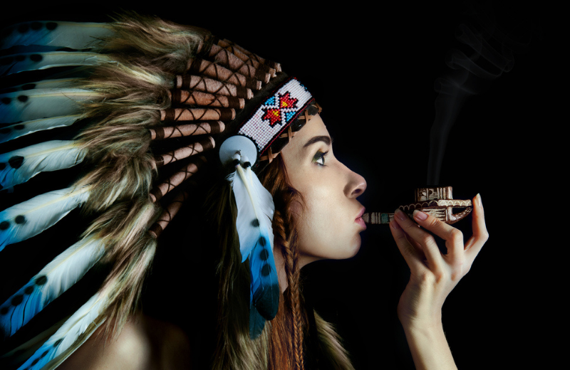 native american woman smoking the Calumet (Peace Pipe)