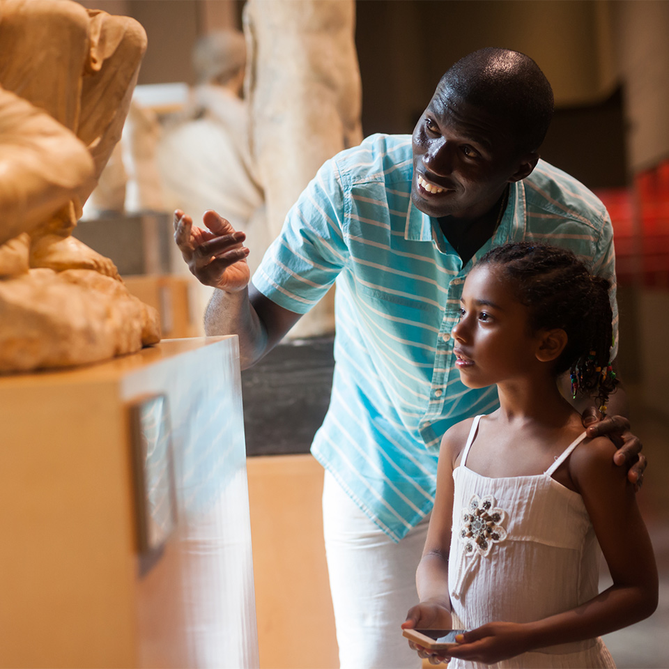 Father and his daughter looking at exhibits in a museum