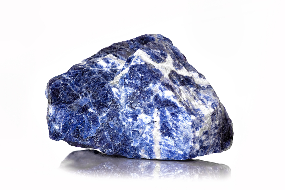 A piece of raw Sodalite on a white background