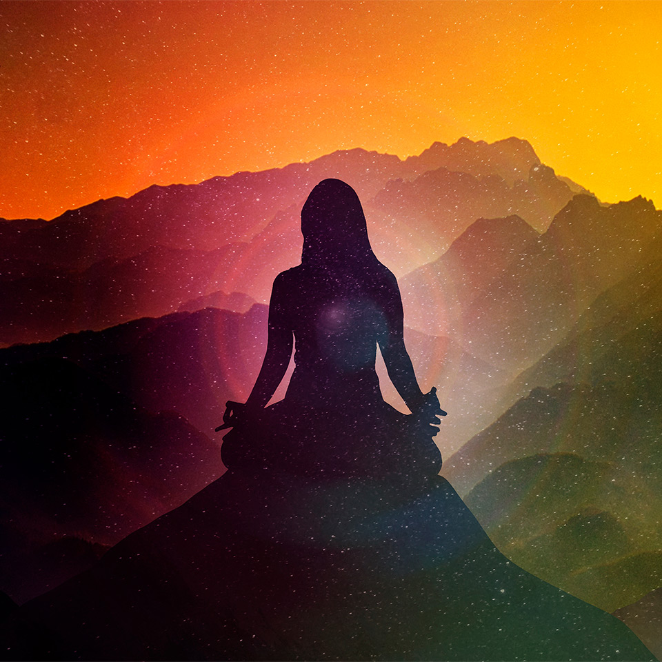 Silhouette of a meditating woman over a mountainous background